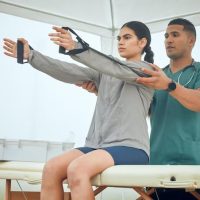 hold-me-cropped-shot-handsome-young-male-physiotherapist-working-female-patient-outside_590464-64861_resultado